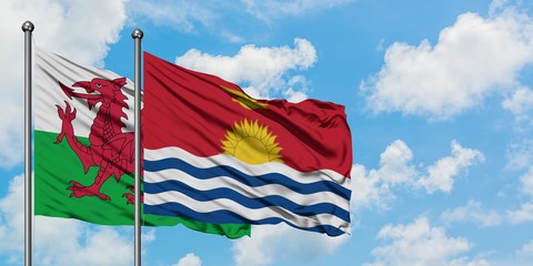 Wales and Kiribati flag waving in the wind against white cloudy blue sky together. Diplomacy concept, international relations.