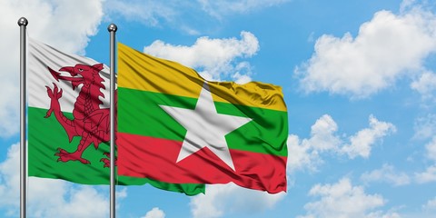 Wales and Myanmar flag waving in the wind against white cloudy blue sky together. Diplomacy concept, international relations.