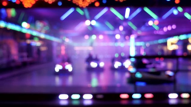 Steady wide shot of blurred bumper car lights at carnival festival,real time