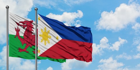 Wales and Philippines flag waving in the wind against white cloudy blue sky together. Diplomacy concept, international relations.