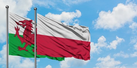 Wales and Poland flag waving in the wind against white cloudy blue sky together. Diplomacy concept, international relations.