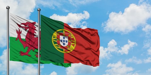 Wales and Portugal flag waving in the wind against white cloudy blue sky together. Diplomacy concept, international relations.