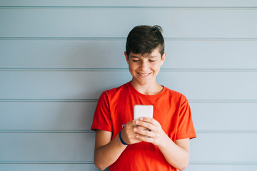 Profile of a happy male teen texting on a smart phone