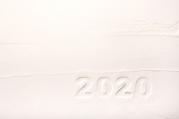 Contours of the figures 2020 on flour. Christmas white texture background.
