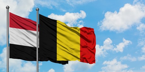 Yemen and Belgium flag waving in the wind against white cloudy blue sky together. Diplomacy concept, international relations.