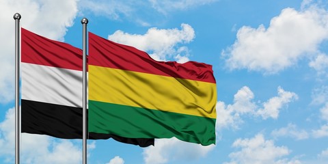 Yemen and Bolivia flag waving in the wind against white cloudy blue sky together. Diplomacy concept, international relations.