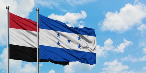Yemen and Honduras flag waving in the wind against white cloudy blue sky together. Diplomacy concept, international relations.