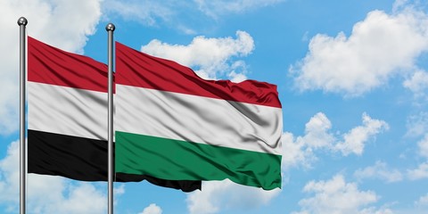Yemen and Hungary flag waving in the wind against white cloudy blue sky together. Diplomacy concept, international relations.