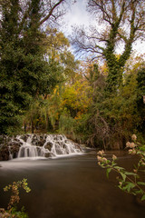 river with waterfall in the autumn season