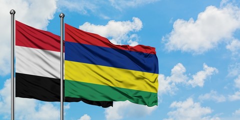 Yemen and Mauritius flag waving in the wind against white cloudy blue sky together. Diplomacy concept, international relations.