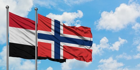 Yemen and Norway flag waving in the wind against white cloudy blue sky together. Diplomacy concept, international relations.