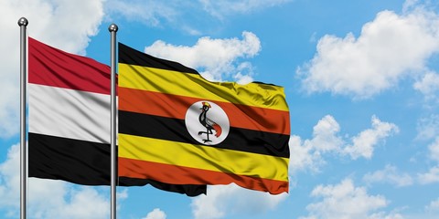 Yemen and Uganda flag waving in the wind against white cloudy blue sky together. Diplomacy concept, international relations.