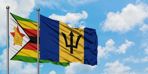 Zimbabwe and Barbados flag waving in the wind against white cloudy blue sky together. Diplomacy concept, international relations.