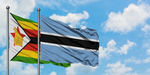 Zimbabwe and Botswana flag waving in the wind against white cloudy blue sky together. Diplomacy concept, international relations.