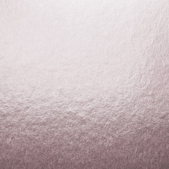 Rose gold pink purple color shiny paper foil leaf texture background with bright brilliant reflective glossy metallic material surface.