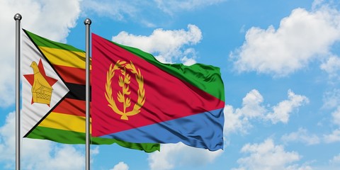 Zimbabwe and Eritrea flag waving in the wind against white cloudy blue sky together. Diplomacy concept, international relations.