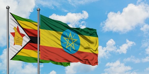 Zimbabwe and Ethiopia flag waving in the wind against white cloudy blue sky together. Diplomacy concept, international relations.