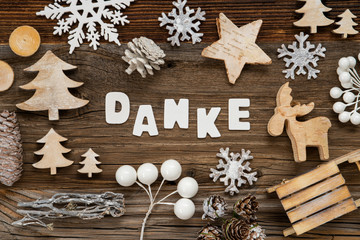 Obraz na płótnie Canvas Letters Building The Word Danke Means Thank You. Wooden Christmas Decoration Like Tree, Sled And Star. Brown Wooden Background