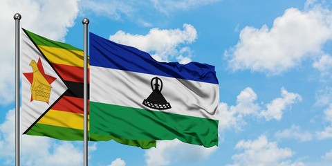 Zimbabwe and Lesotho flag waving in the wind against white cloudy blue sky together. Diplomacy concept, international relations.
