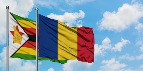 Zimbabwe and Romania flag waving in the wind against white cloudy blue sky together. Diplomacy concept, international relations.