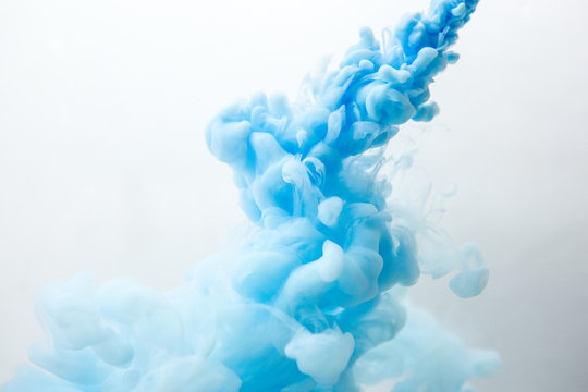 Abstract flowing liquid or blue ink in water on a white background. It looks like smoke or cloud. Or zero gravity.