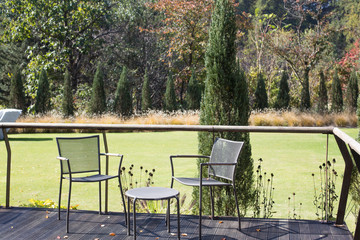 Table and chairs in a terrace by the lush green trees