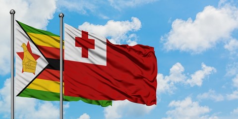 Zimbabwe and Tonga flag waving in the wind against white cloudy blue sky together. Diplomacy concept, international relations.