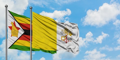Zimbabwe and Vatican City flag waving in the wind against white cloudy blue sky together. Diplomacy concept, international relations.