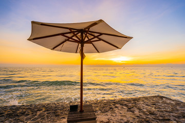 Umbrella and chair with pillow around beautiful landscape of beach and sea