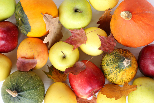 many pumpkins and apples with autumn leaves top view. colorful thanksgiving day