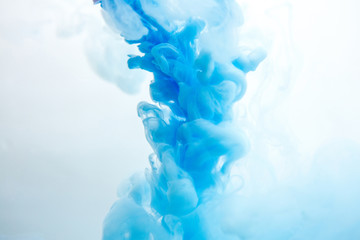 Abstract flowing liquid or blue ink in water on a white background. It looks like smoke or cloud. Or zero gravity.