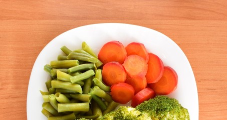 boiled green beans and carrots on a white plate