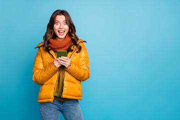 Photo of nice cute millennial lady hold telephone read positive comments enjoy followers reposts wear stylish fall windbreaker jeans scarf isolated blue color background © deagreez