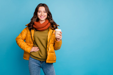 Photo of pretty millennial lady holding hot takeout coffee beverage wear stylish autumn windbreaker jeans scarf pullover isolated blue color background © deagreez