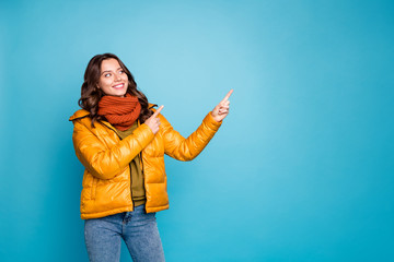 Photo of pretty cute lady indicating fingers empty space showing best shopping prices wear stylish autumn windbreaker jeans scarf pullover isolated blue color background © deagreez