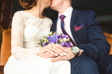 close-up of the hands of the groom with the clock and the bride