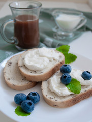 sandwiches with cream cheese and cocoa blueberries and milk in the background