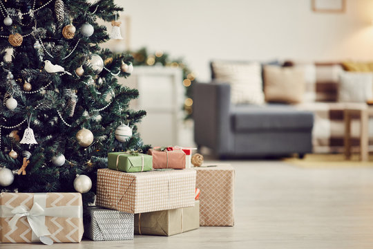 Image of decorated Christmas tree with gift boxes under it on the floor in the living room