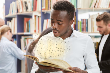 African man looks in awe at book - obrazy, fototapety, plakaty