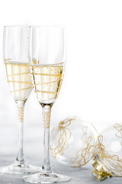Greeting card: Christmas and New Year concept. 2 glasses of champagne with Christmas balls on a white background