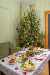 Festive Christmas served table against beautiful green pine tree decorated with many colorful new year toys. Xmas dinner, delicious food, christmas turkey. Winter holidays celebration at cozy home