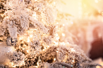 Christmas tree branch with decorations New Year gift ball snowflakes close up, silver white color