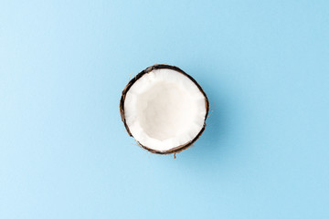 Fototapeta premium Half of fresh coconut on blue background. Top view