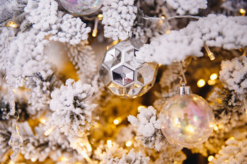 Christmas white tree decorated snow illumination and gifts toys, background light bokeh