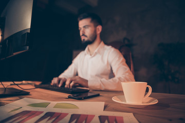 Profile side photo of concentrated collar worker sit table work on computer finish presentation read data statistics with white coffee double espresso cup mug on desk stay in evening dark office
