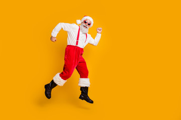 Fototapeta na wymiar Full size profile side photo of funky crazy fairy grey hair beard santa claus hipster in red hat jump go run winter time tradition x-mas discounts isolated yellow color background