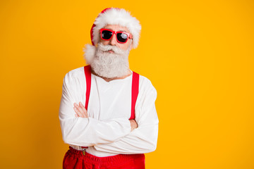 Fototapeta na wymiar Portrait of serious santa claus from noel north-pole in red hat cross hands look confident on x-mas newyear party isolated over shine color background