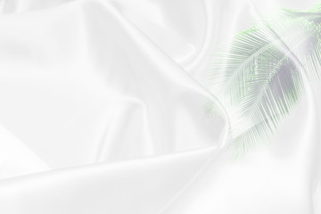 green palm leaves pattern overlay with white fabric texture soft blur background