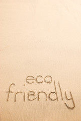 Fototapeta na wymiar Eco friendly message handwritten on the beach with natural smooth sand copy space