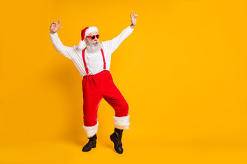 Fototapeta na wymiar X-mas festive celebration. Full size photo of crazy funky old santa claus clubber in red hat enjoy christmas noel fairy party dance wear shirt suspenders isolated yellow color background